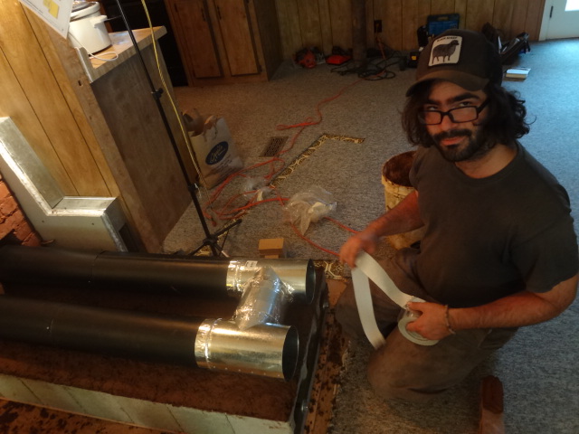 Taping up the joints of the pipes that will be in the cob bench