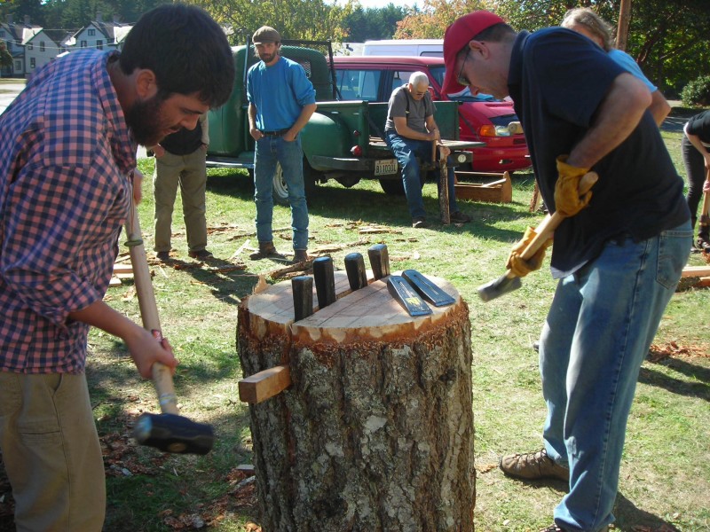 As the metal wedges begin to split the log, you can add wooden wedges along the side of the split to help it along